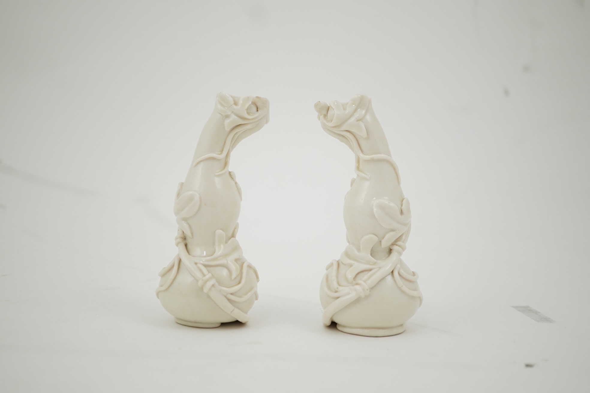 A pair of Chinese blanc-de-chine gourd-shaped vases, Dehua kilns, Qing dynasty